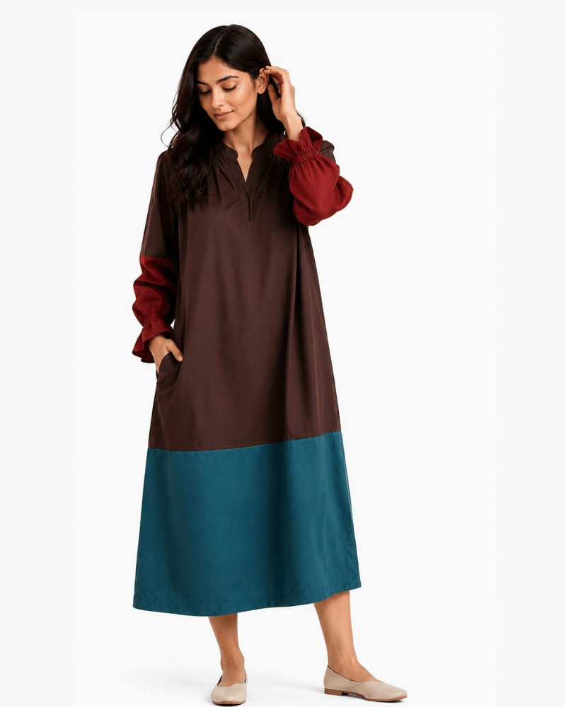 Woman styling a brown and teal colour block dress with rust-red sleeves