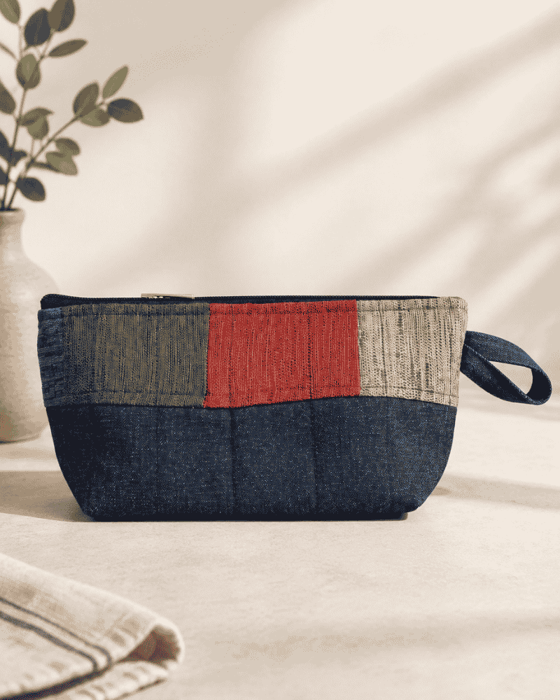 Blue denim utility pouch with red and dark patchwork detail
