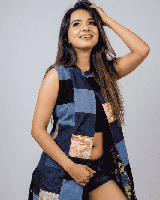 Woman wearing a sleeveless blue and black patchwork denim jacket with beige and light blue fabric panels, Bunko Junko.
