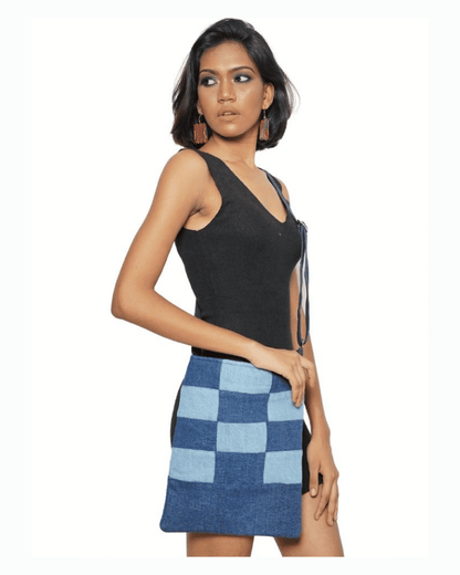 Blue patchwork denim crossbody bag shown on a woman