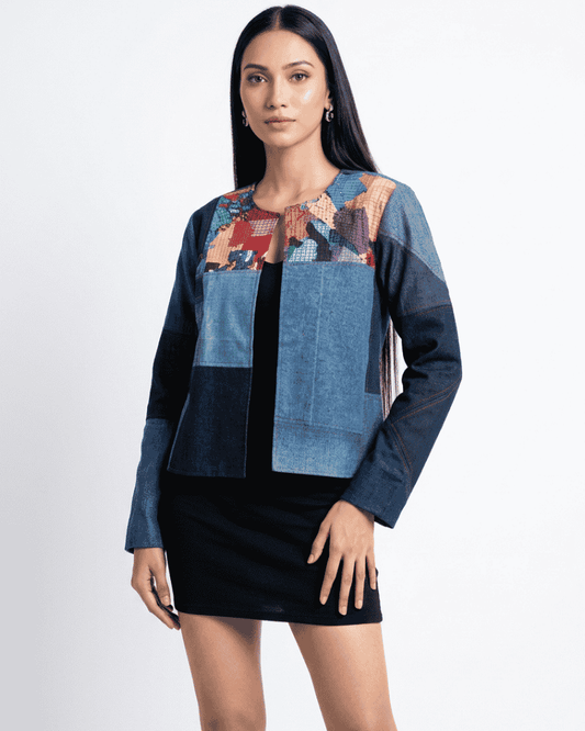 Woman wearing a blue patchwork denim jacket with light blue and dark blue geometric panels over a black dress, Bunko Junko.
