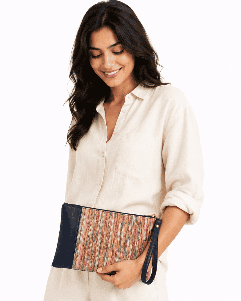 Woman holding a Rang Woven Clutch with multicolour woven textile and wristlet strap
