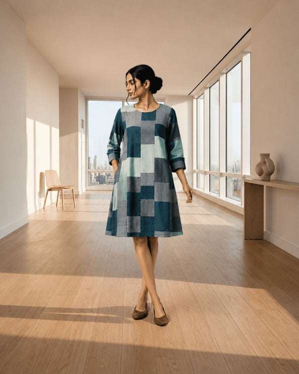 Model wearing a blue and grey colour block knee length dress with three-quarter sleeves, Bunko Junko.