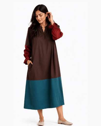 Woman styling a brown and teal colour block dress with rust-red sleeves