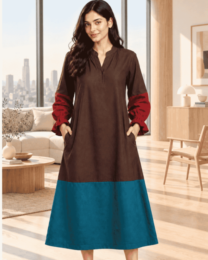 Woman wearing a brown and teal colour block dress with rust-red sleeves