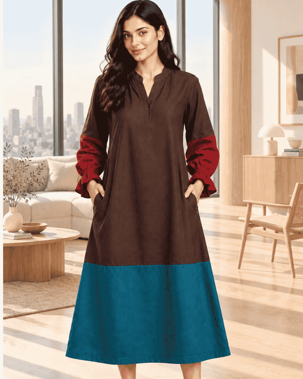 Woman wearing a brown and teal colour block dress with rust-red sleeves