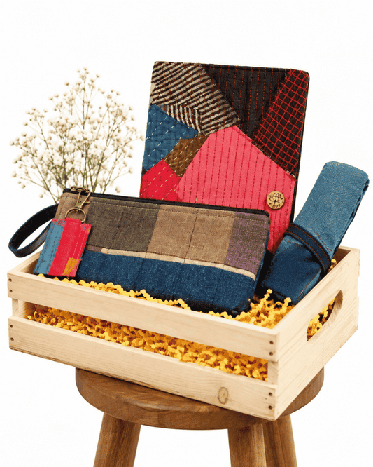 Miss in Mist gift hamper with a colourful patchwork diary, zip pouch, fabric keychain and rolled blue tie in a wooden crate.