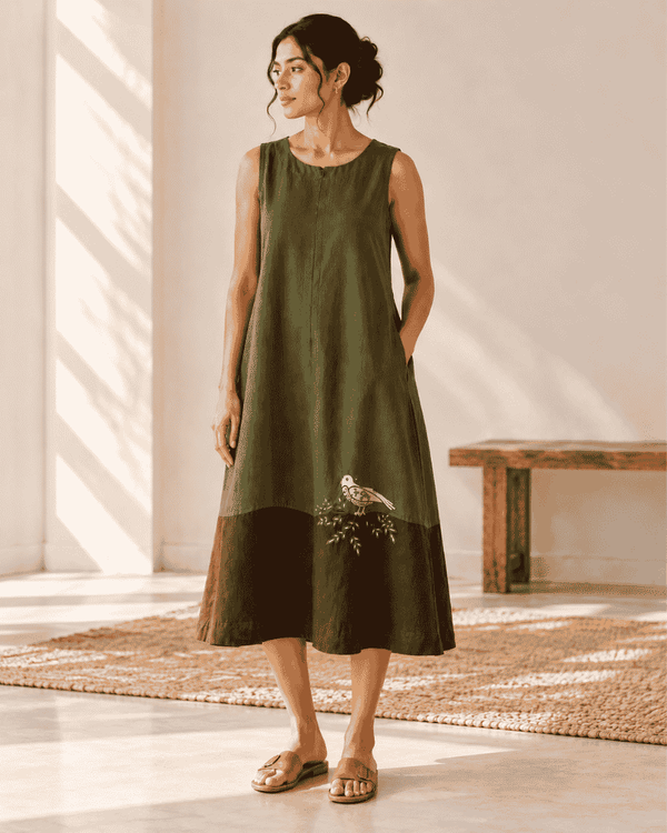 Woman wearing an olive-green and brown Mora midi dress with bird and branch motif