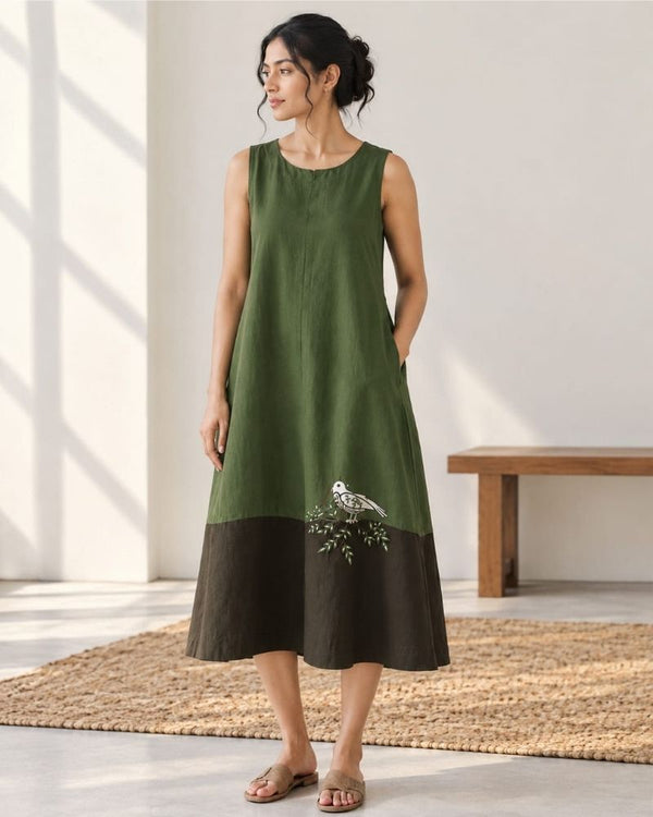 Woman wearing an olive green and brown Mora midi dress with bird and branch motif