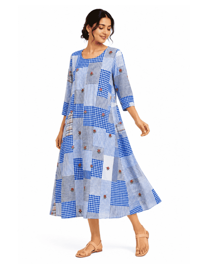 Woman wearing the Nilaya blue patchwork dress with mixed textile patterns