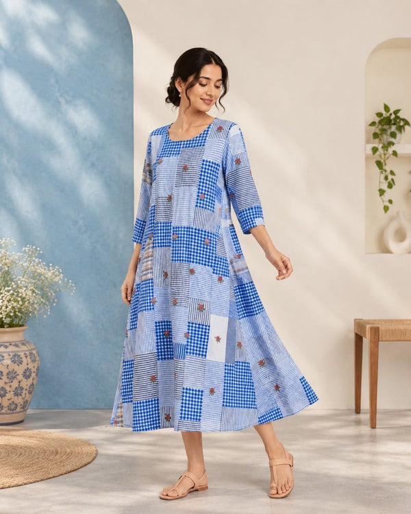 Woman wearing the Nilaya blue patchwork dress with mixed textile patterns