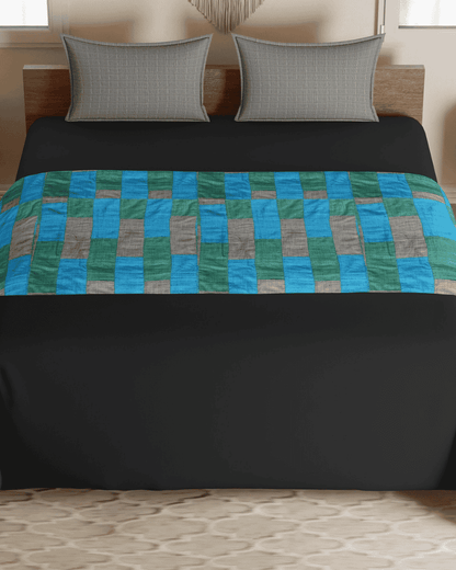 Patch Fusion upcycled bed runner styled on a blue bed