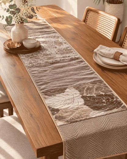 Beige and brown patchwork table runner with leaf and chevron patterns on a dining table, Bunko Junko.