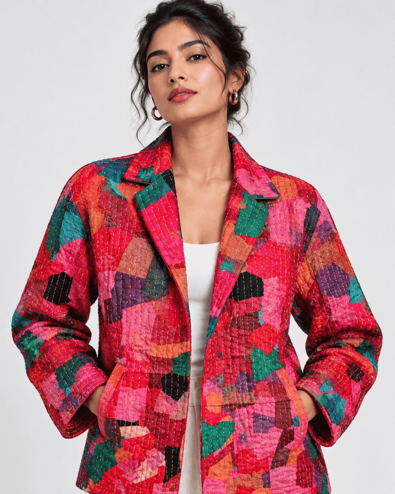 Model wearing a pink and red jacket made from patchwork style fabric.
