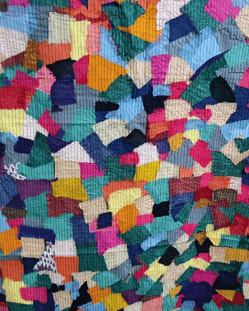 Blue and multicolour upcycled textile panel with geometric fabric pieces.
