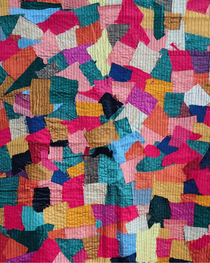 Pink and blue upcycled textile scrap panel with mixed fabric patterns.
