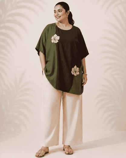 Woman styling an olive and brown Vanya tunic dress with floral embroidery
